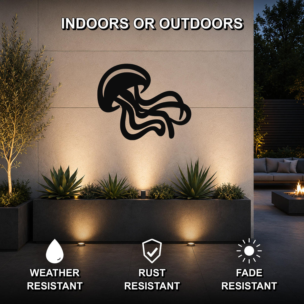 Black metal jellyfish wall art with flowing tentacle cutouts, mounted on an outdoor wall above a planter in a modern patio setting.