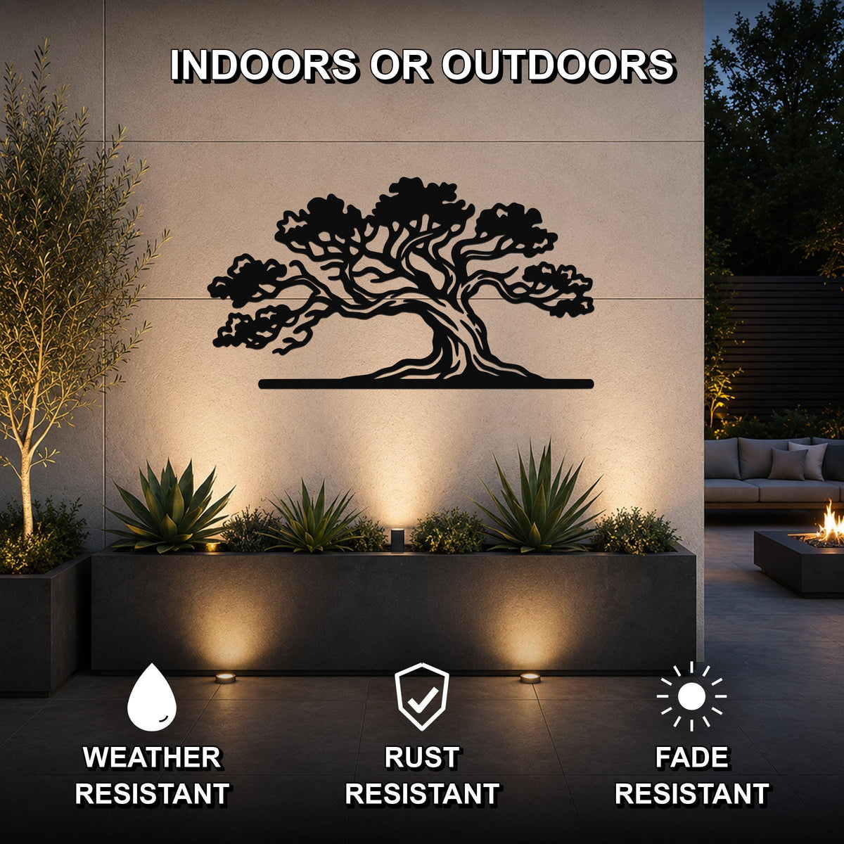 Black metal juniper tree wall art with intricate branch cutouts, mounted on an outdoor wall above a planter in a modern patio setting.