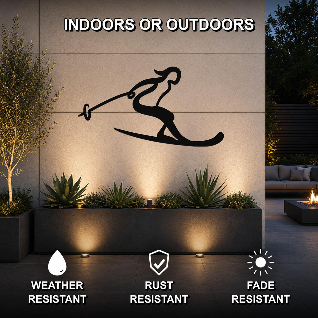 Black metal wall art of a skier silhouette with ski poles and skis, mounted on an outdoor wall above a planter in a patio setting.