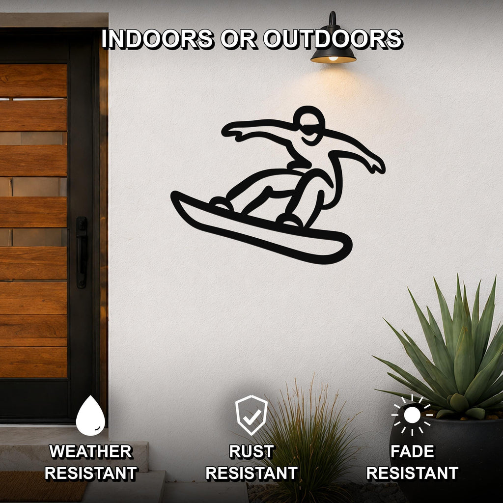 Black metal wall art silhouette of a snowboarder in motion, mounted on an outdoor wall beside a wooden door and potted plants.