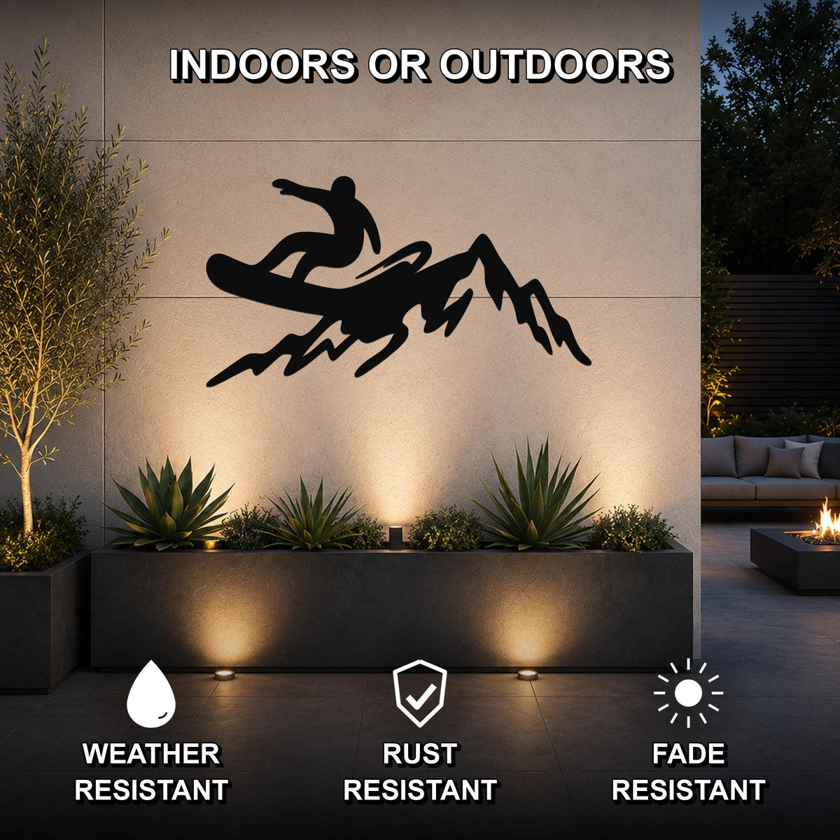 Black metal wall art silhouette of a snowboarder on a mountain, mounted on an outdoor wall above a planter in a modern patio setting.
