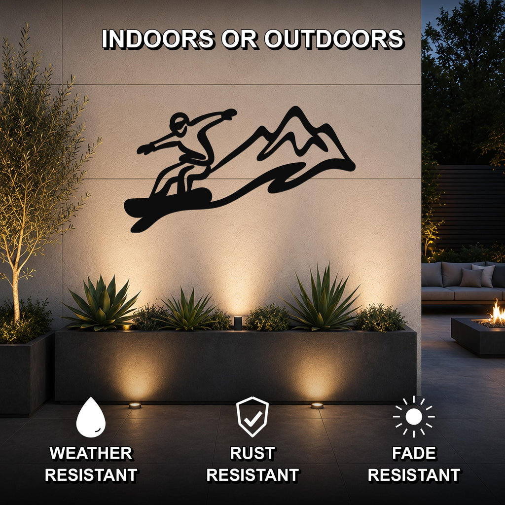 Black metal snowboarder wall art with mountain silhouette, mounted on an outdoor wall above a planter in a patio setting.