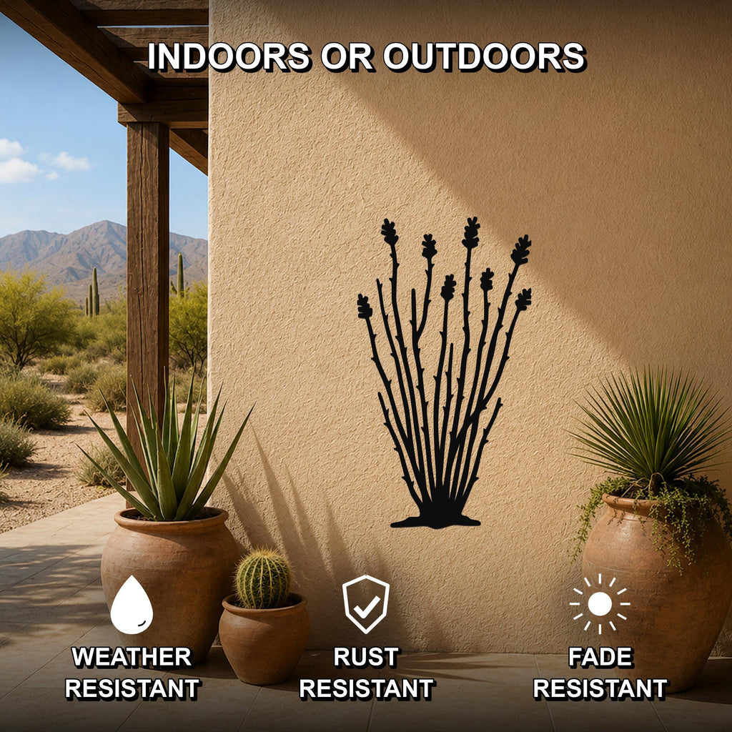 Black metal ocotillo wall art silhouette with branching stems and flower cutouts, mounted on a beige outdoor wall beside potted desert plants on a patio.