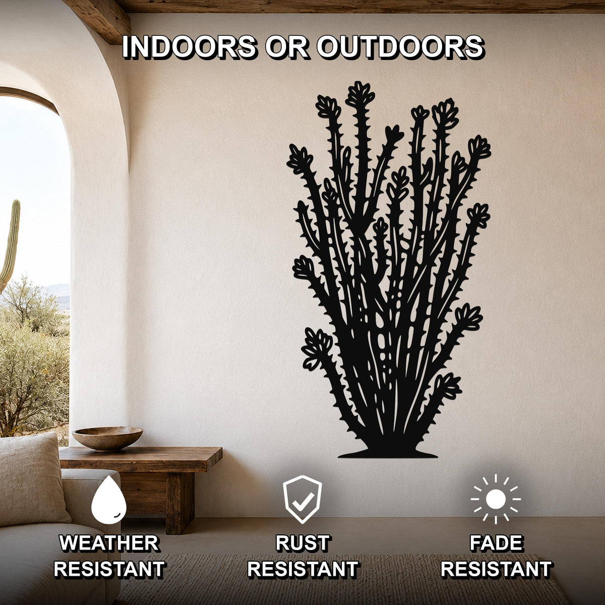 Black metal ocotillo wall art with detailed spines and flower cutouts, mounted on a beige wall in a living room with an arched doorway and wooden furniture.