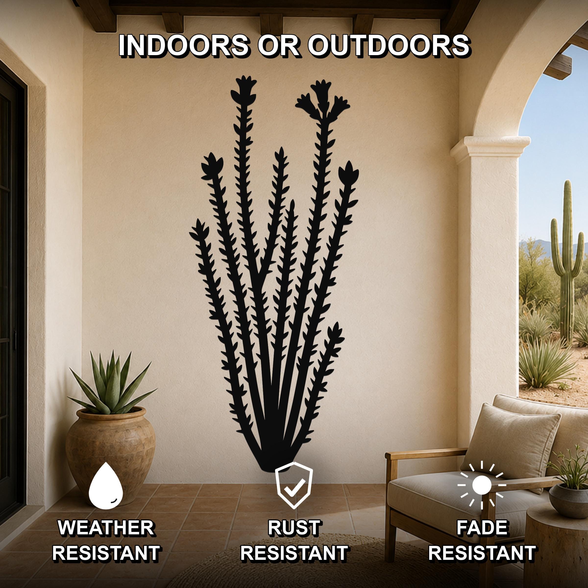 Black metal ocotillo wall art with spiny branch cutouts, mounted on a beige patio wall above a chair, shown in an indoor-outdoor setting.