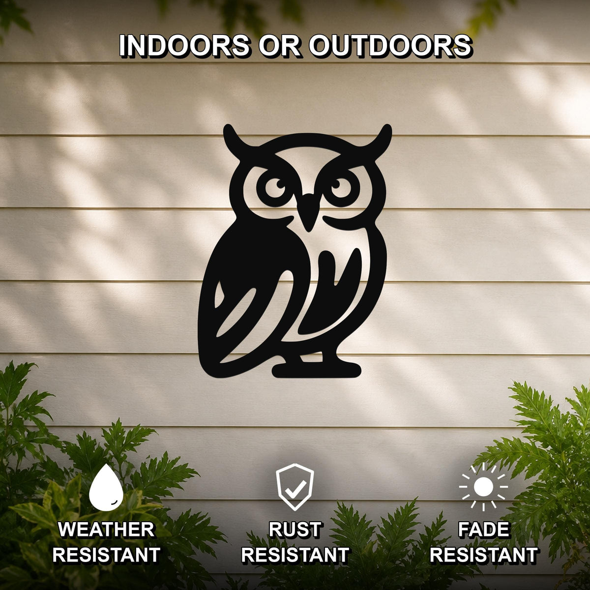 Black metal owl wall art with cutout details, mounted on a light-colored outdoor wall with greenery, weather resistant, rust resistant, and fade resistant.