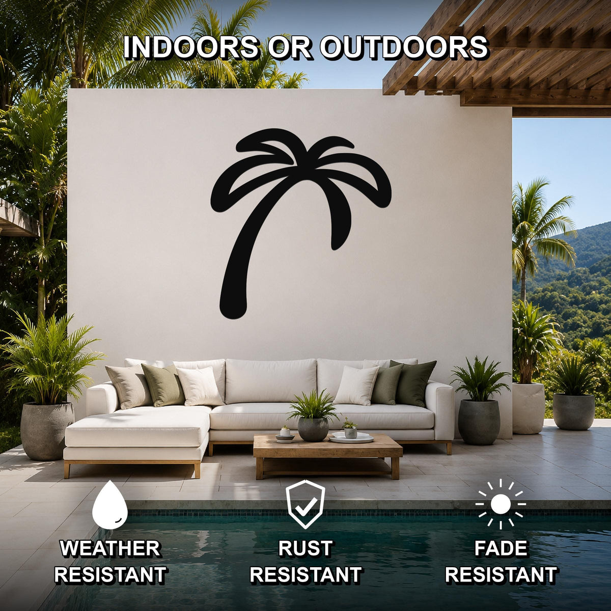 Black metal palm tree wall art silhouette mounted on a white outdoor wall above a white sectional sofa in a patio setting.