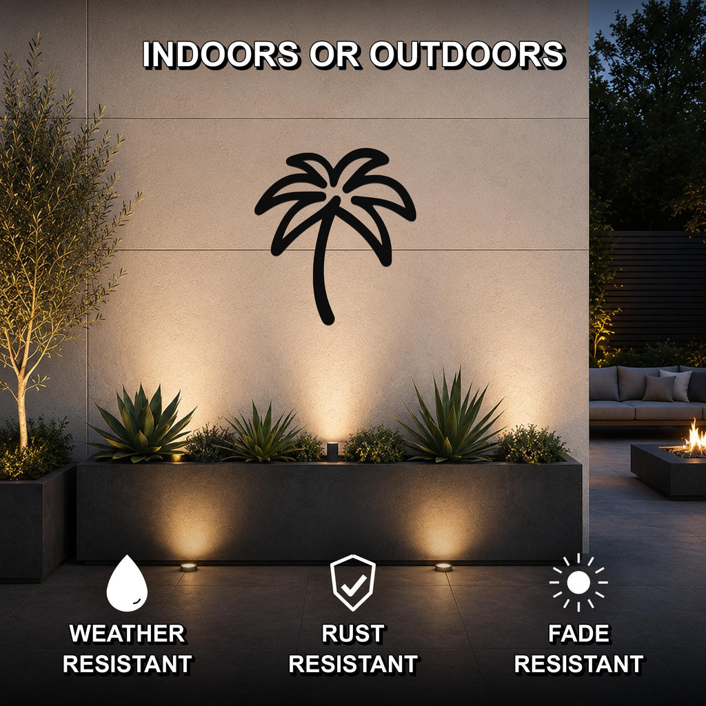 Black metal palm tree wall art with cutout silhouette, mounted on an outdoor wall above a planter in a patio setting.