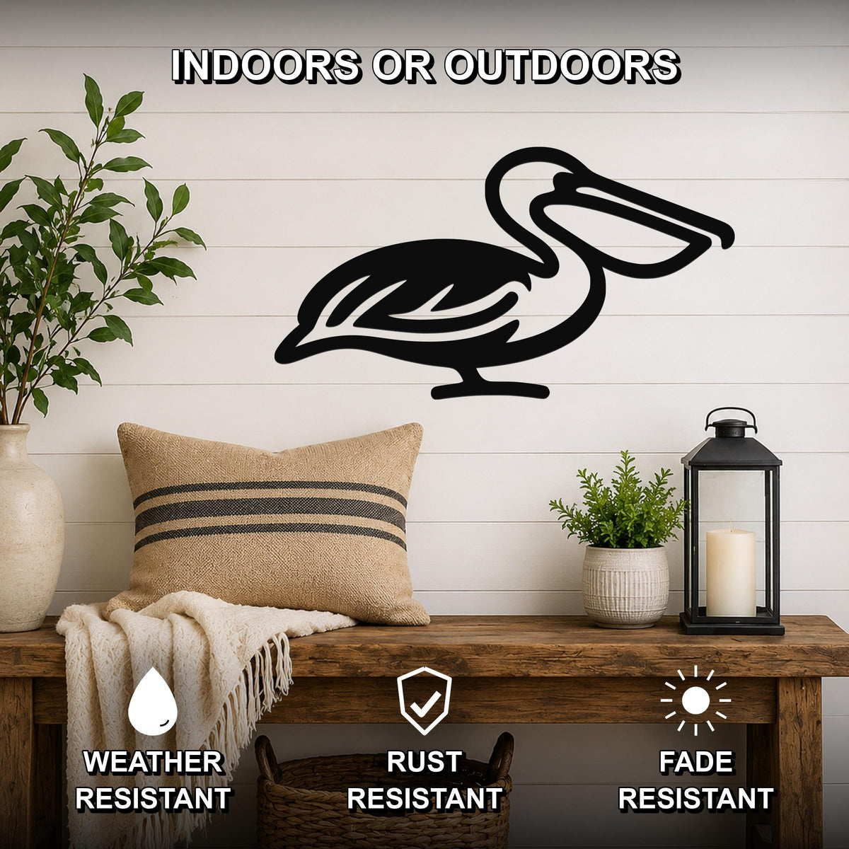 Black metal pelican wall art silhouette mounted on a white shiplap wall above a wooden bench in a living room.