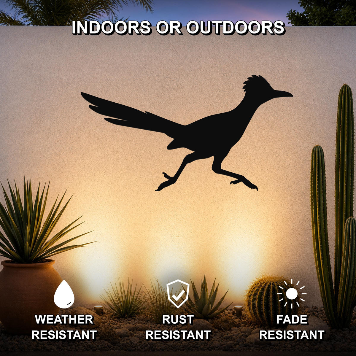 Black metal roadrunner wall art silhouette mounted on an outdoor wall above a desert garden with cacti and succulents.
