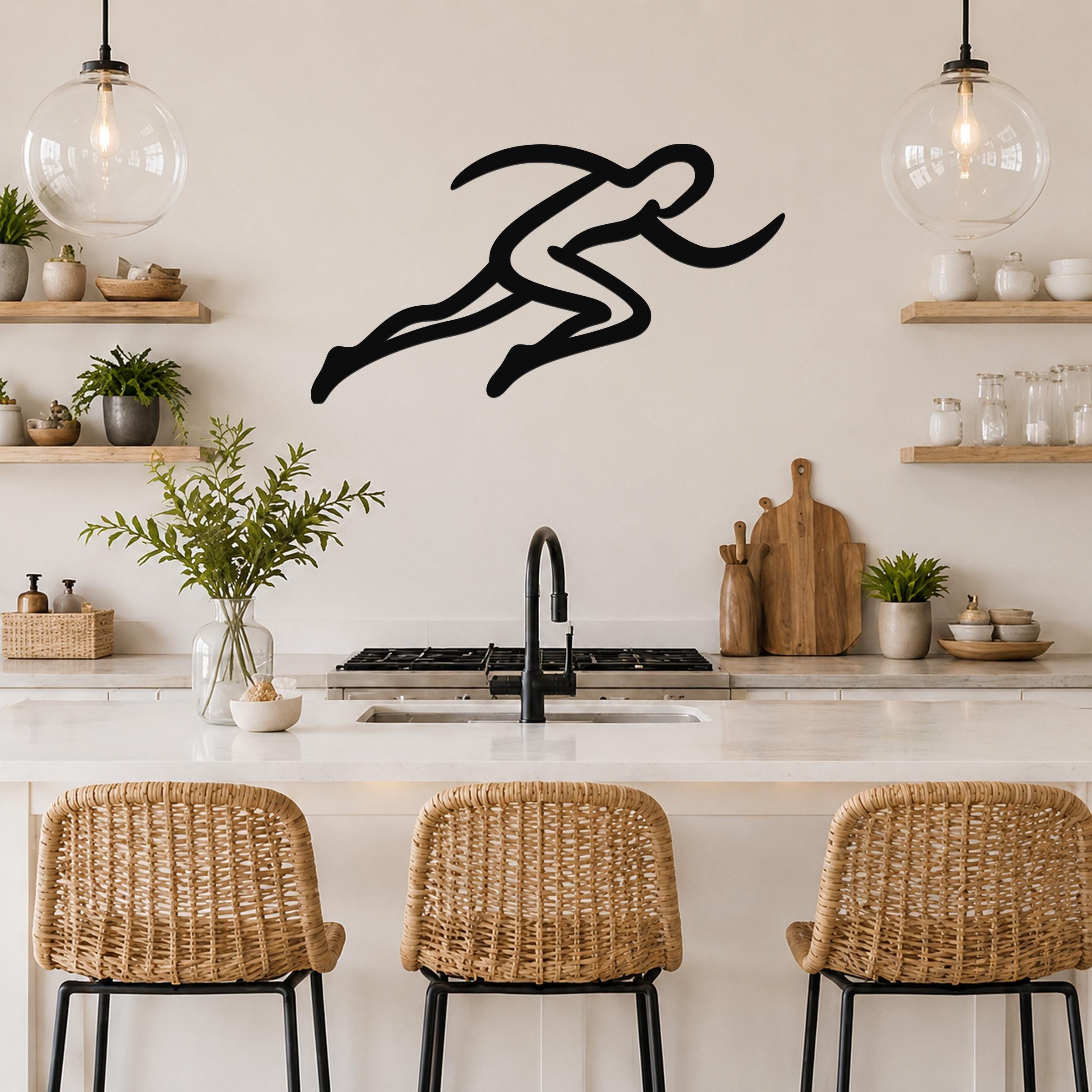 Black metal runner wall art with motion-line cutouts, mounted above a kitchen counter in a modern kitchen.