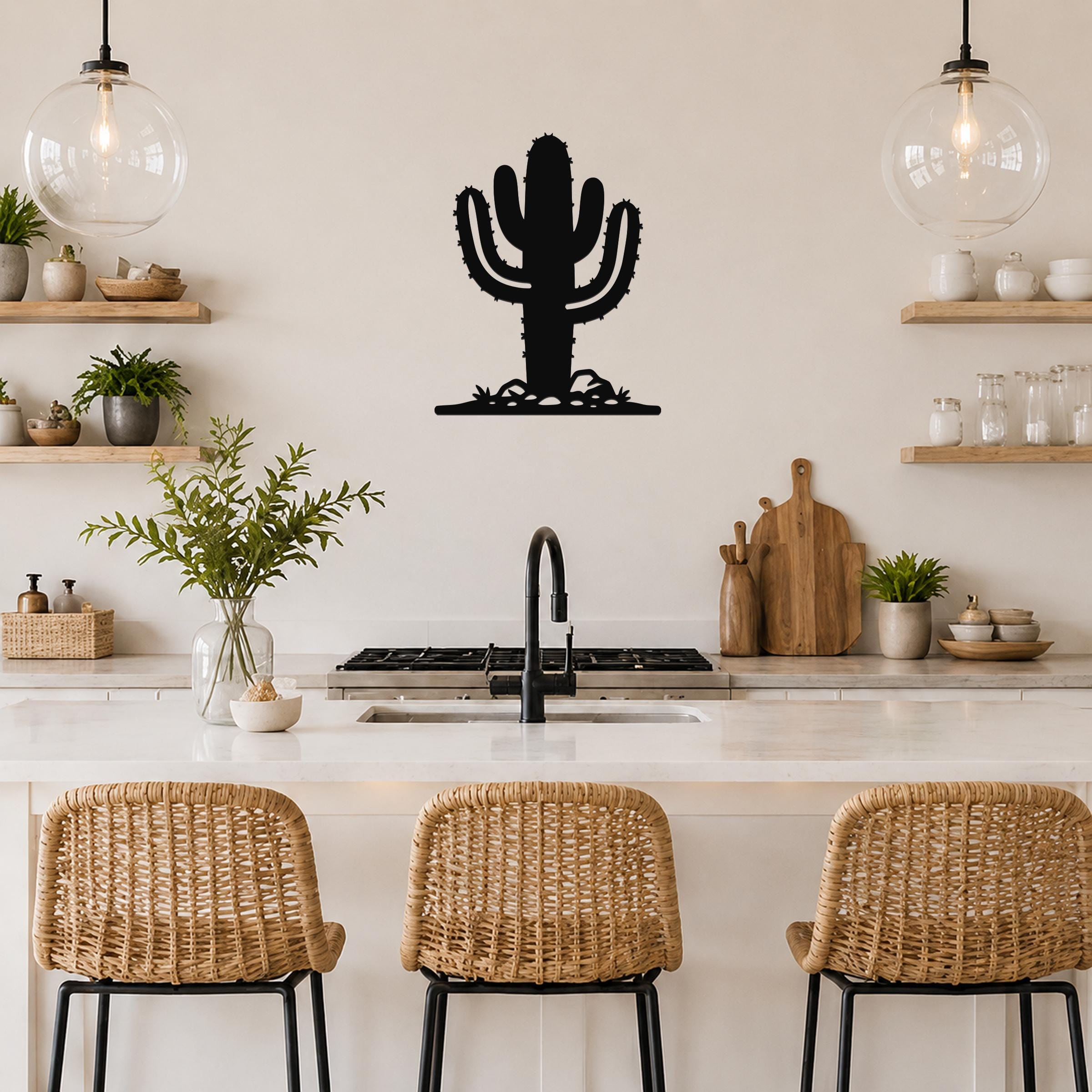Black metal Saguaro cactus wall art with spines and base cutouts, mounted on a kitchen wall above a counter.