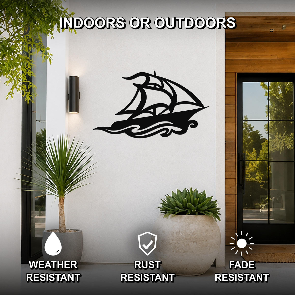 Black metal sailboat wall art with wave cutouts, mounted on a white exterior wall beside a glass door and potted plants.