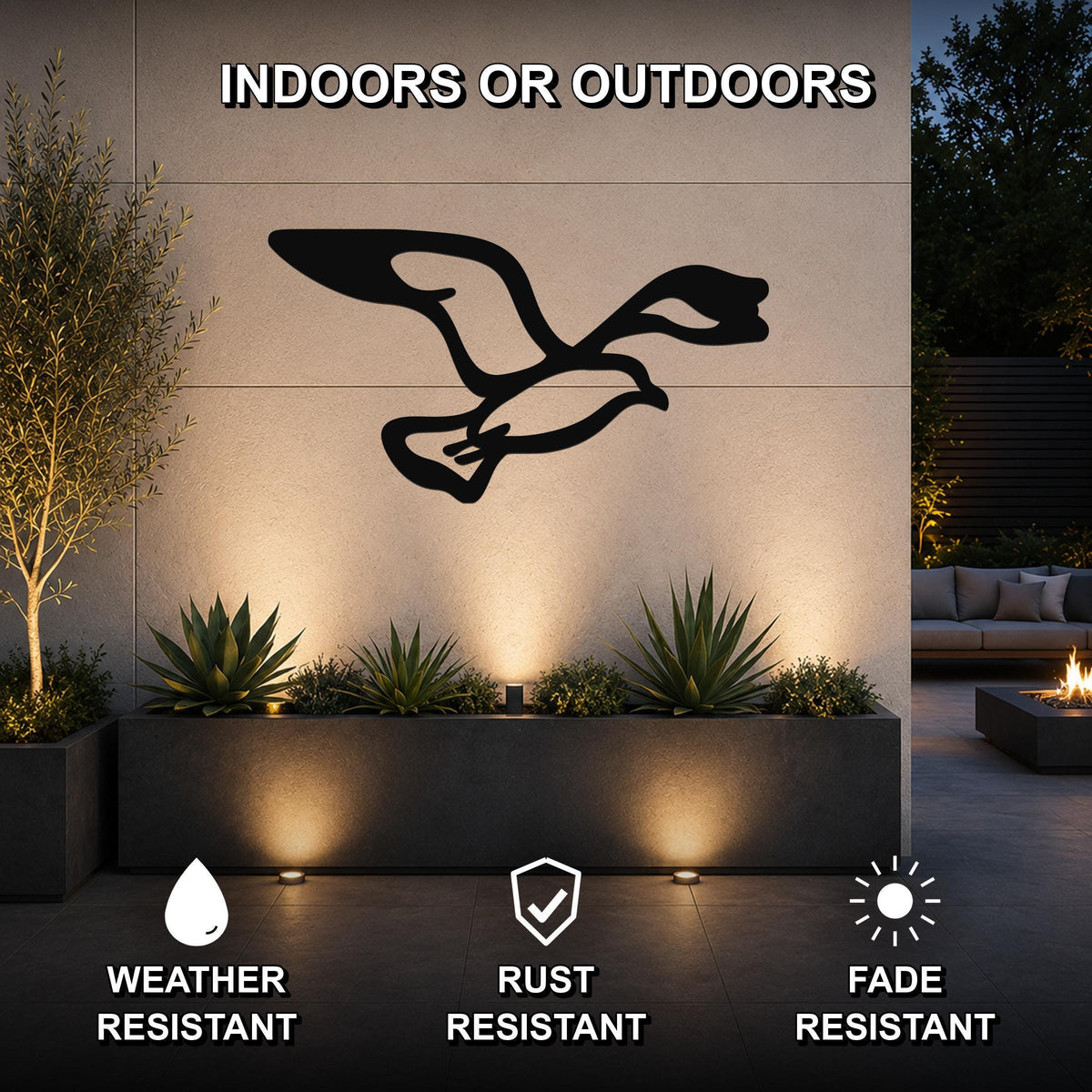 Black metal seagull wall art with wing and tail cutouts, mounted on an outdoor wall above a planter in a modern patio setting.