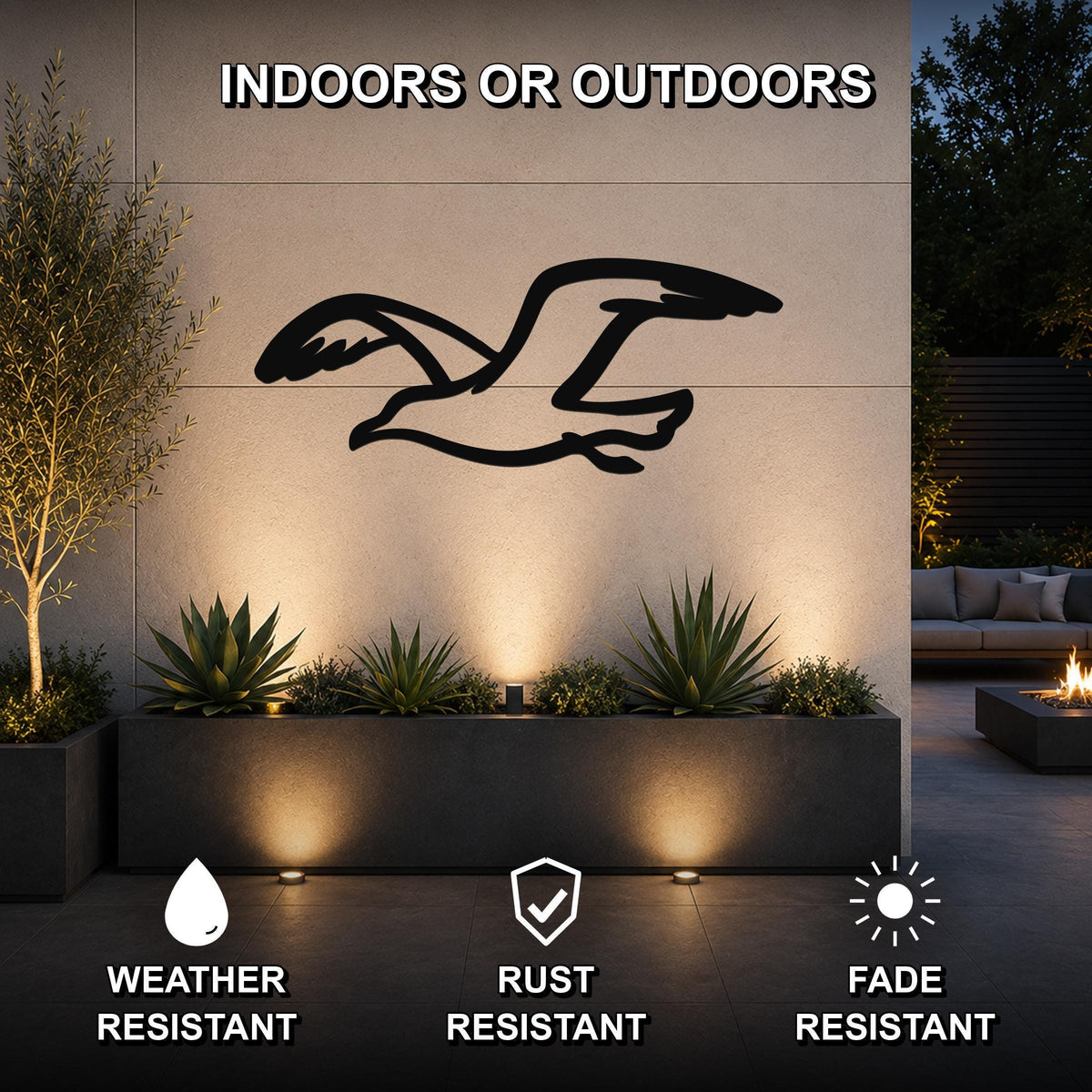 Black metal seagull wall art with motion-line cutouts, mounted on an outdoor wall above a planter in a modern patio setting.