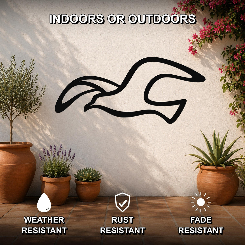 Black metal seagull wall art with motion-line cutouts, mounted on an outdoor patio wall above potted plants.