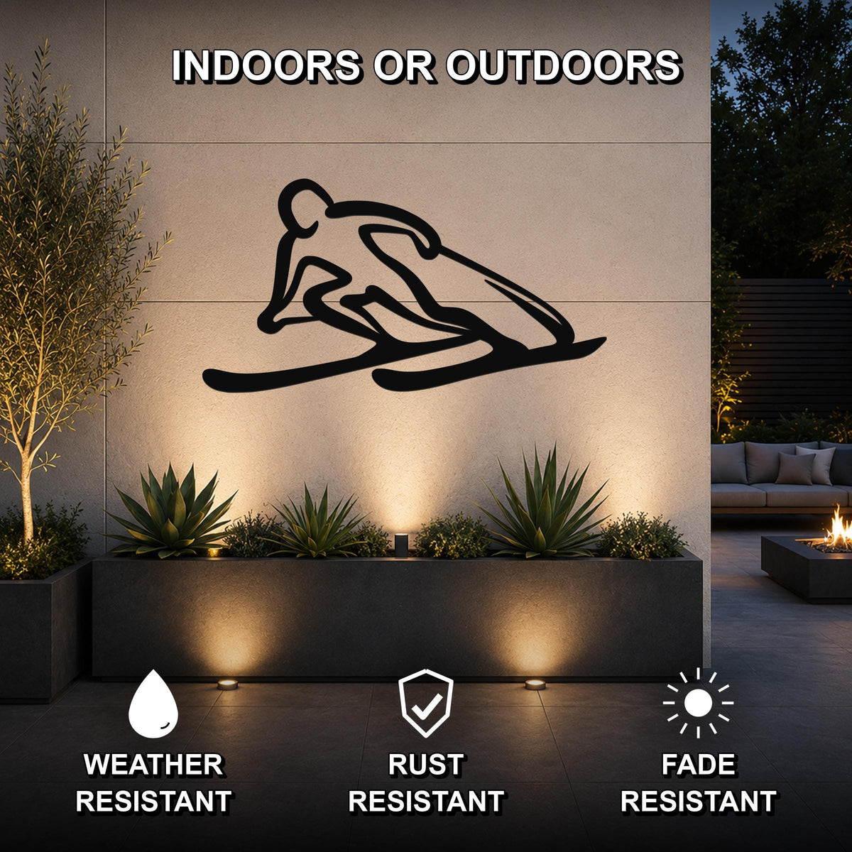 Black metal skier silhouette wall art mounted on an outdoor wall above a planter, with text indicating it is weather, rust, and fade resistant for indoor or outdoor use.