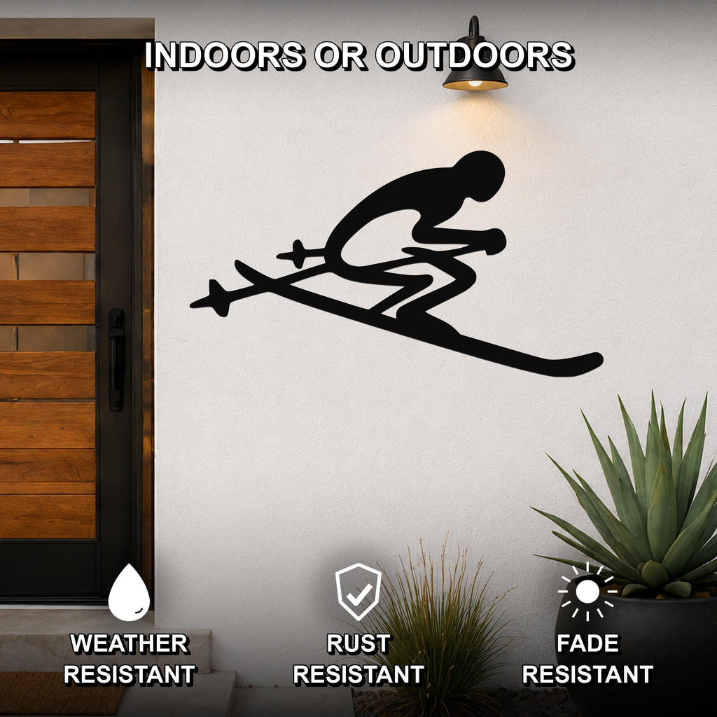 Black metal skiing silhouette wall art with skis and poles, mounted on an outdoor wall beside a wooden door and potted plants.