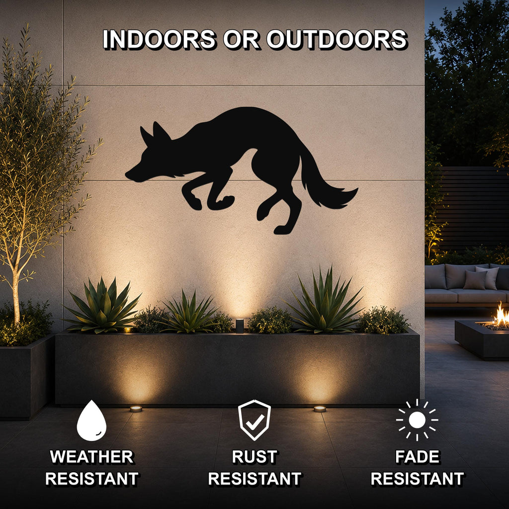Black metal coyote wall art silhouette mounted on an outdoor patio wall above a planter, with text indicating it is weather, rust, and fade resistant for indoor or outdoor use.