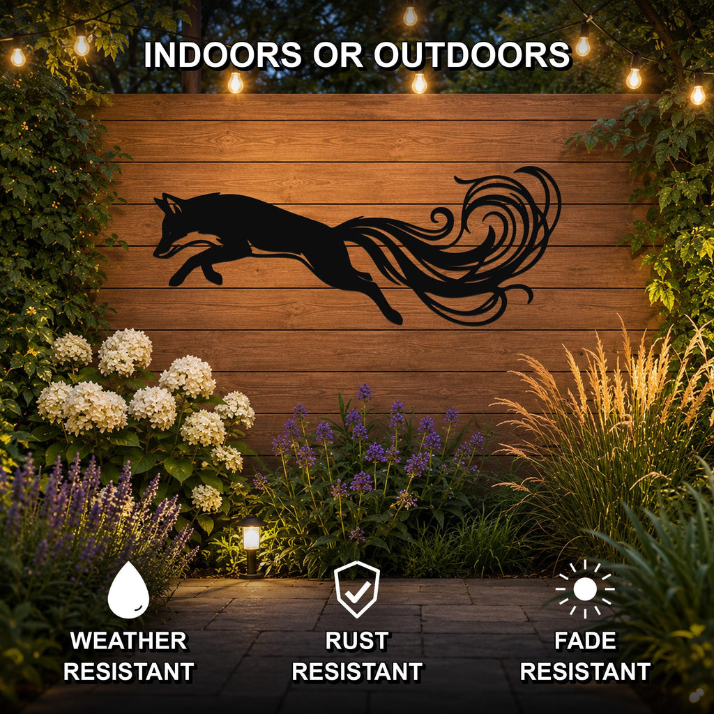 Black metal fox wall art with flowing tail cutout, mounted on a wooden fence in an outdoor garden setting with string lights and plants.