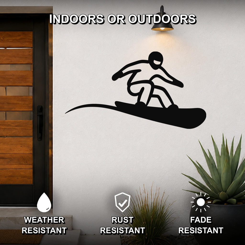 Black metal snowboarder wall art with a dynamic silhouette and motion line, mounted on an outdoor wall beside a door and plants.