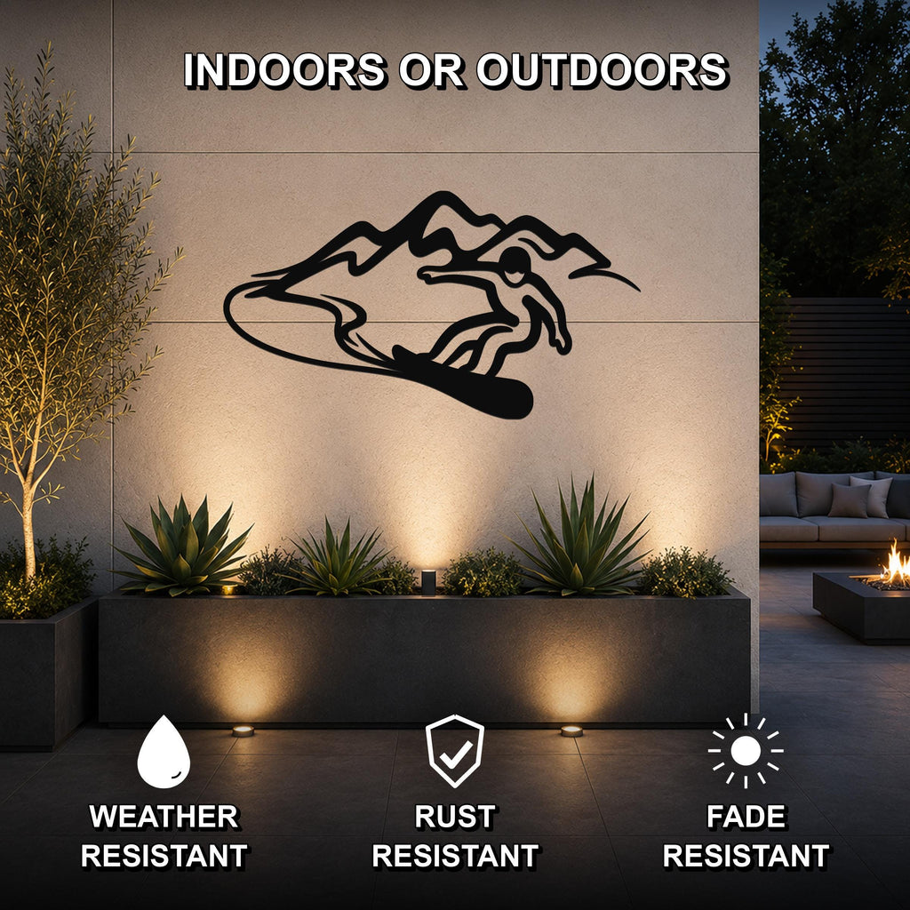 Black metal wall art of a snowboarder in motion against a mountain silhouette, mounted on an outdoor wall above a planter in a patio setting.