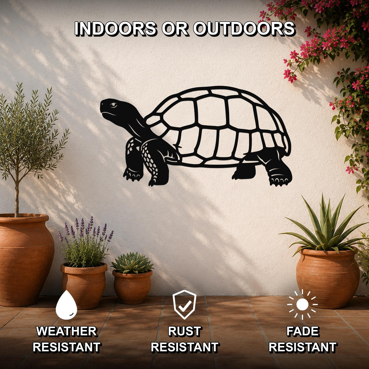 Black metal tortoise wall art with detailed shell and limb cutouts, mounted on a white outdoor wall above potted plants on a tiled patio.