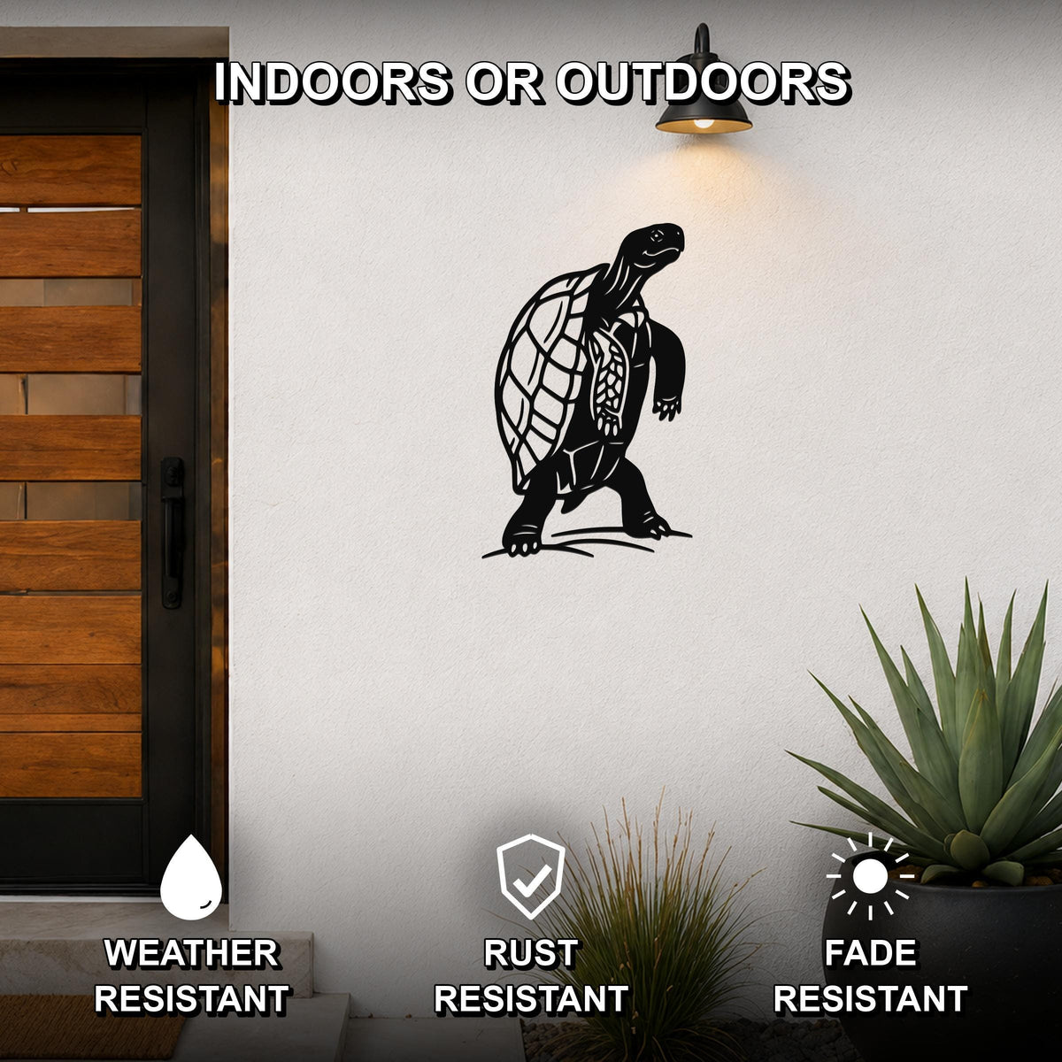 Black metal tortoise wall art with detailed shell cutouts, mounted on an outdoor wall beside a wooden door and potted plants.