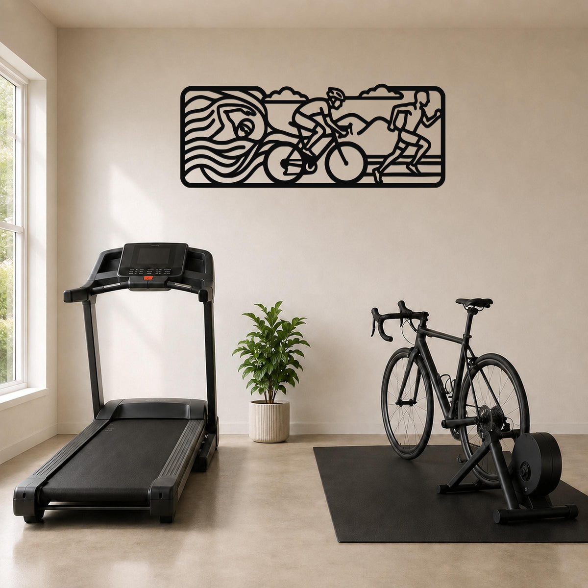 Black metal wall art with a triathlon motif of swim, bike, and run silhouettes, mounted on a wall above a treadmill and exercise bike in a home gym.