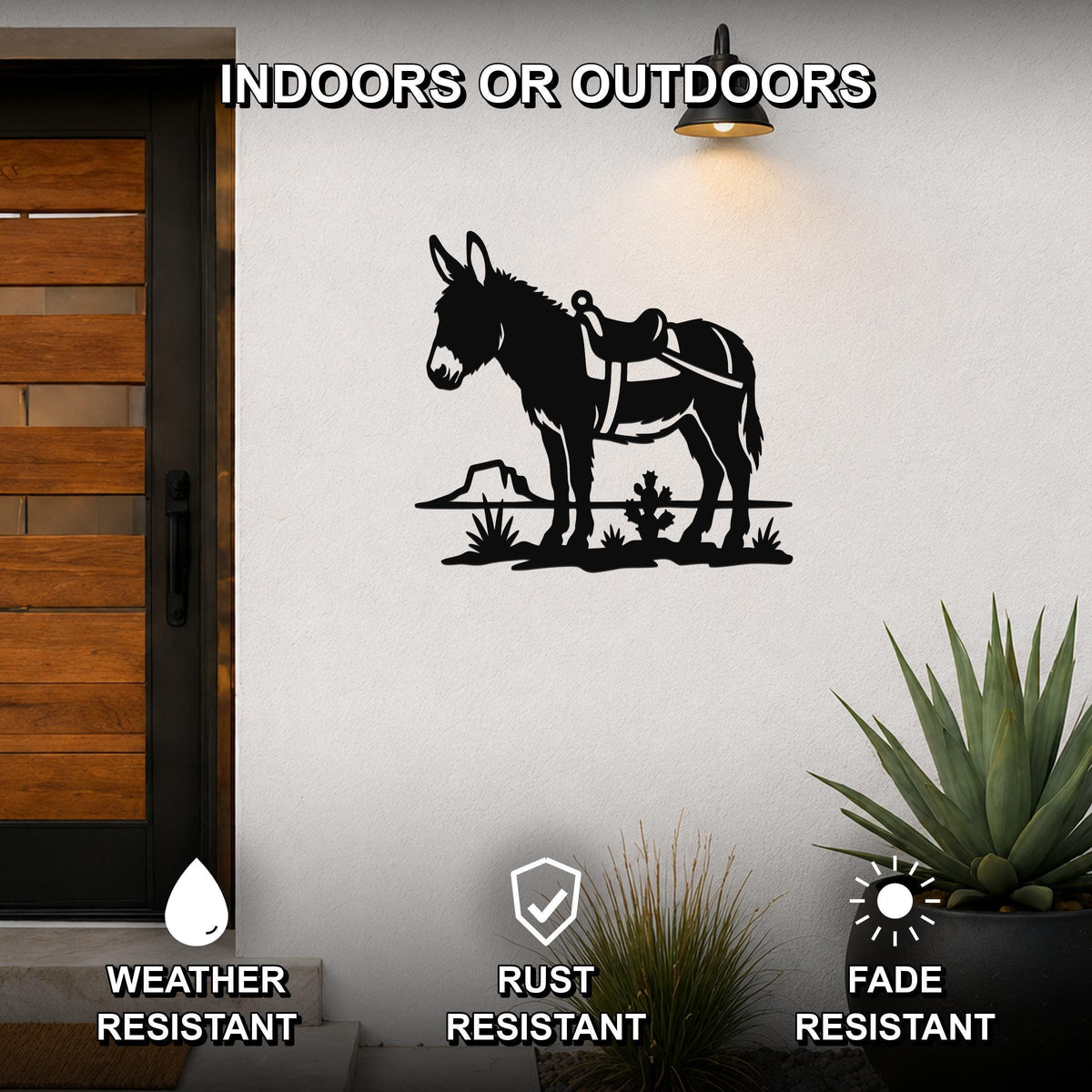 Black metal wall art featuring a burro silhouette with saddle and desert plants, mounted on an outdoor wall beside a door.
