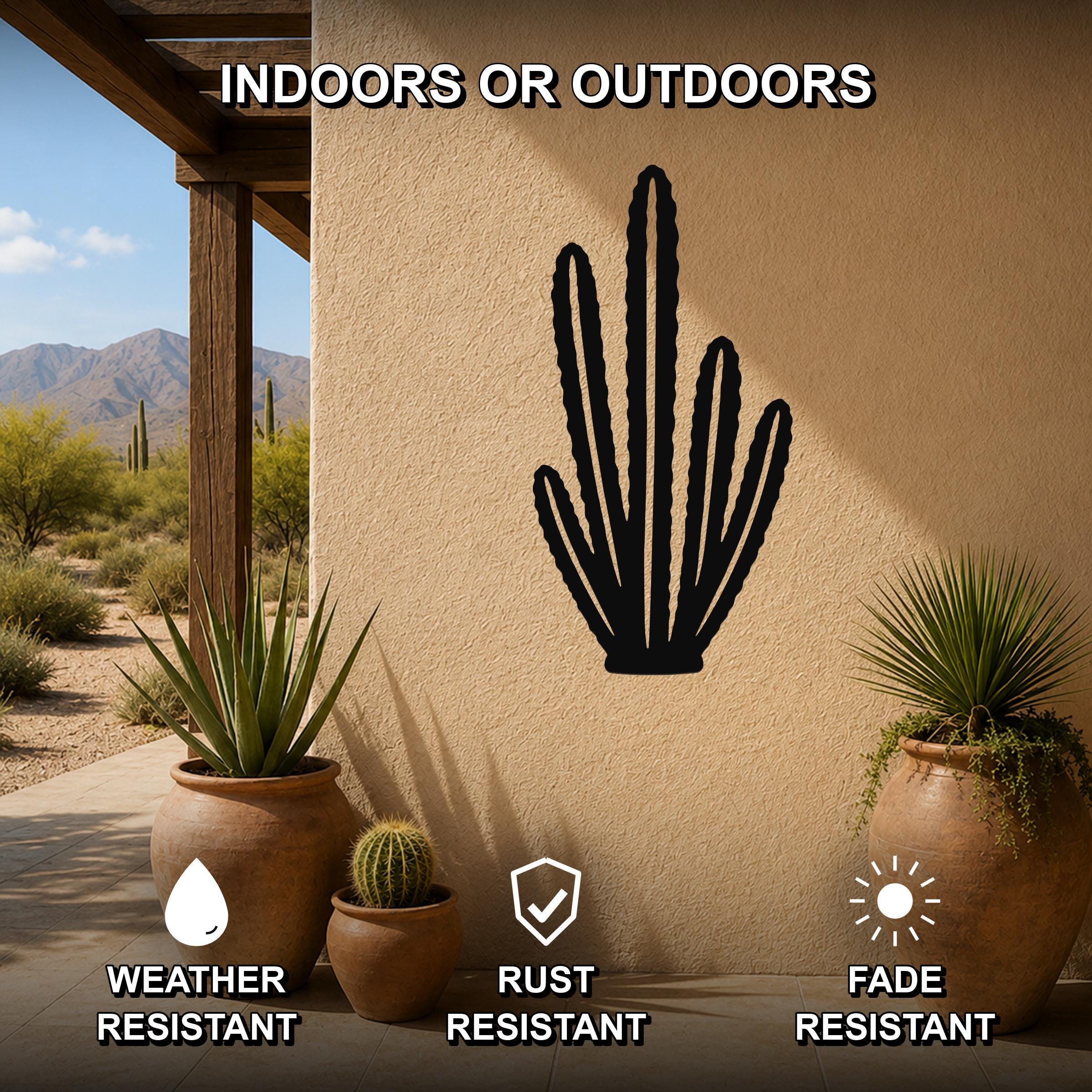 Black metal organ pipe cactus wall art with spiny silhouette cutouts, mounted on a beige outdoor wall above potted plants on a patio.