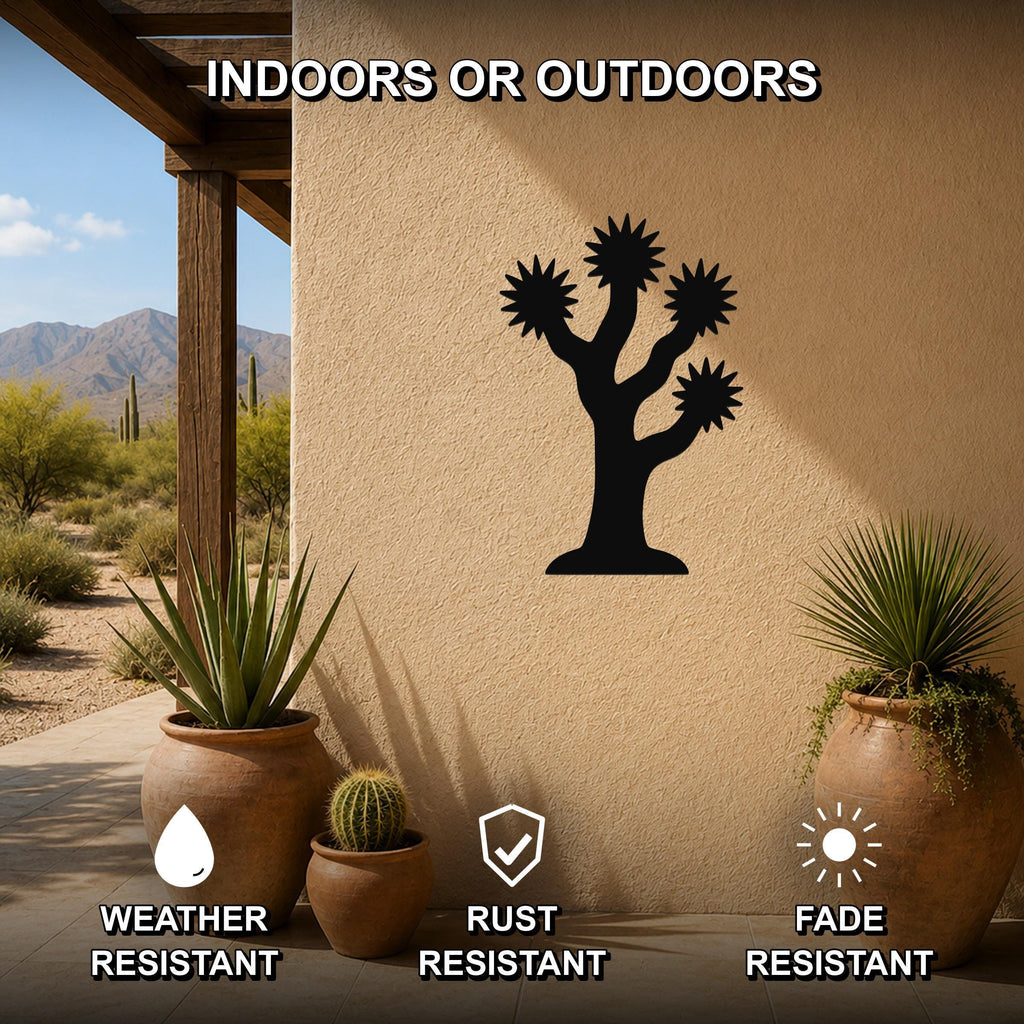 Black metal Joshua tree wall art with branch and starburst cutouts, mounted on an outdoor patio wall above potted plants.