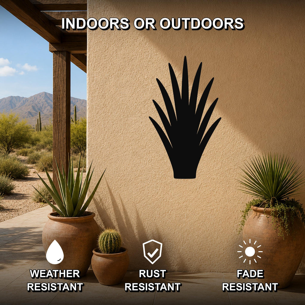 Black metal agave plant wall art silhouette mounted on a stucco outdoor wall, displayed on a patio with potted desert plants and a mountain view.