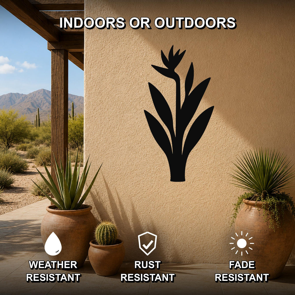 Black metal Bird of Paradise wall art silhouette mounted on an outdoor patio wall, weather resistant, rust resistant, and fade resistant, with potted plants nearby.