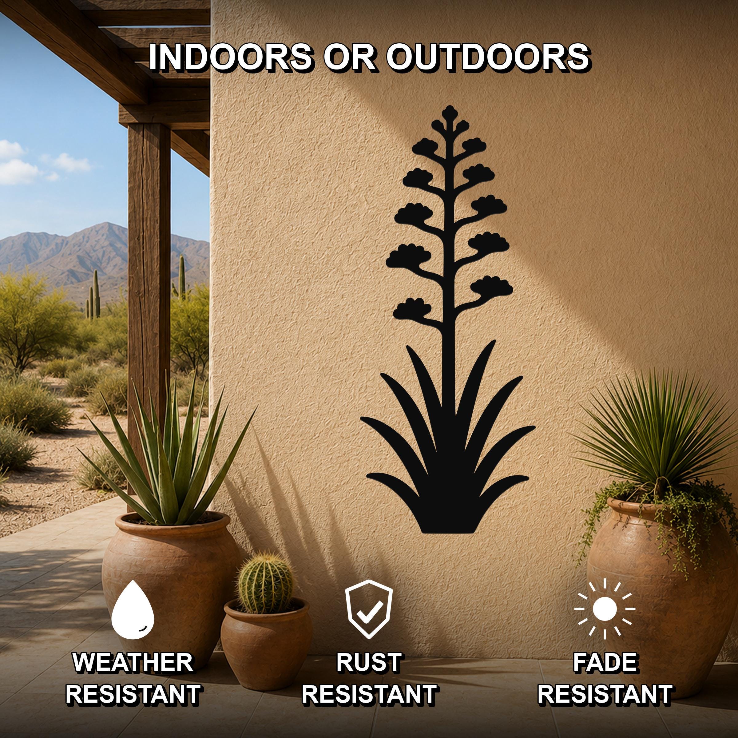 Black metal agave wall art with blooming flower cutout, mounted on an outdoor patio wall above potted plants.