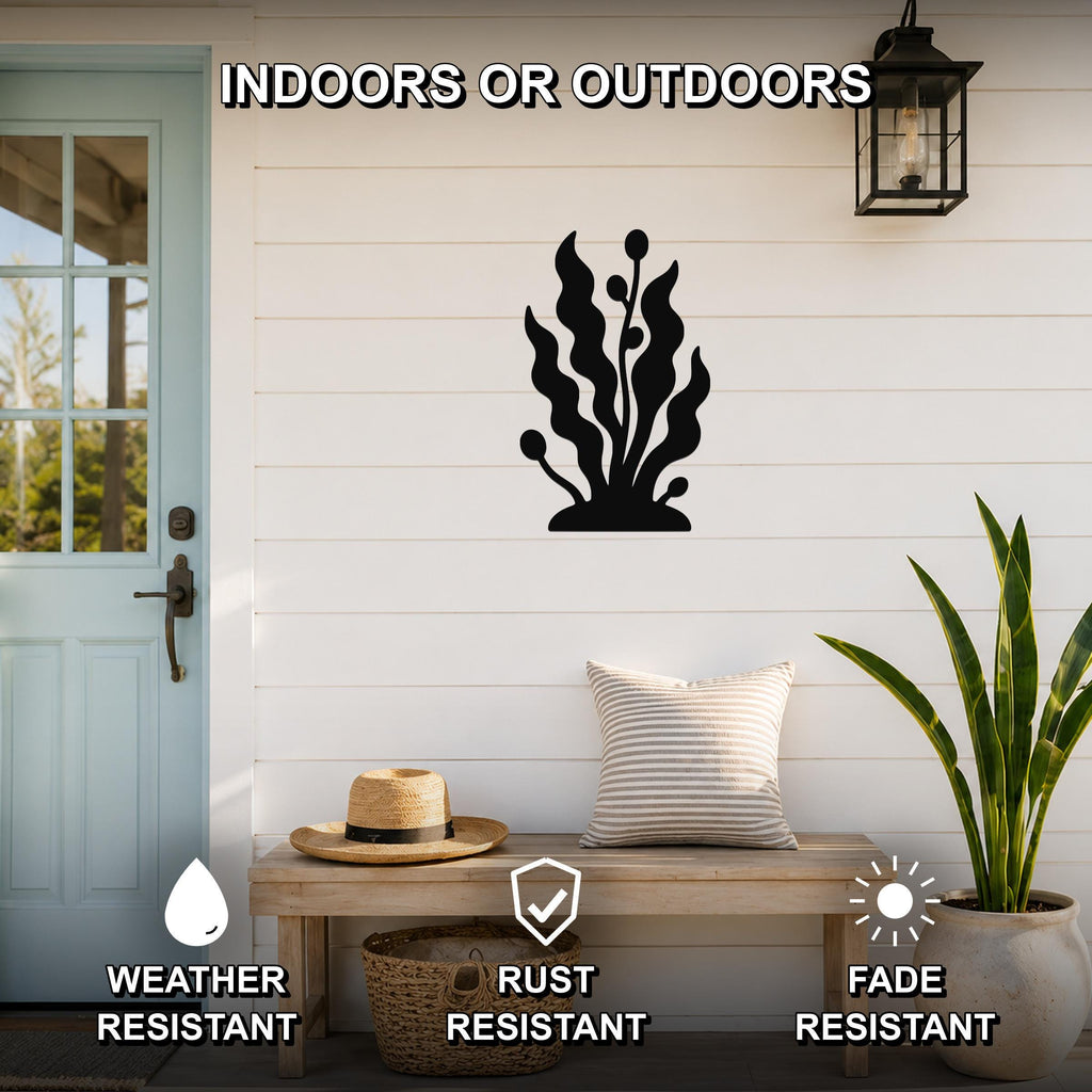 Black metal kelp and seaweed wall art silhouette mounted on a white shiplap wall above a wooden bench in a coastal entryway.