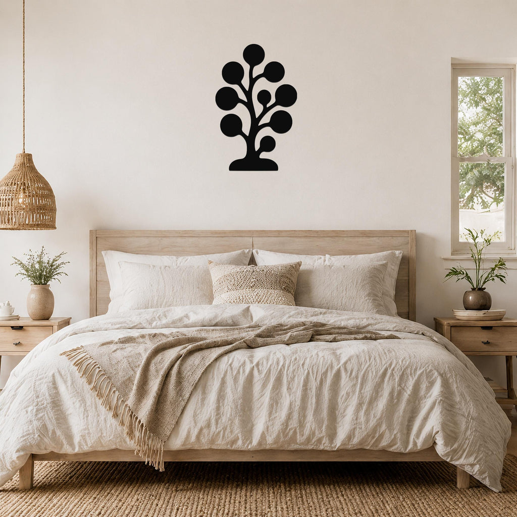 Black metal wall art in a tree silhouette with circular leaf shapes, mounted above a wooden bed in a neutral bedroom.