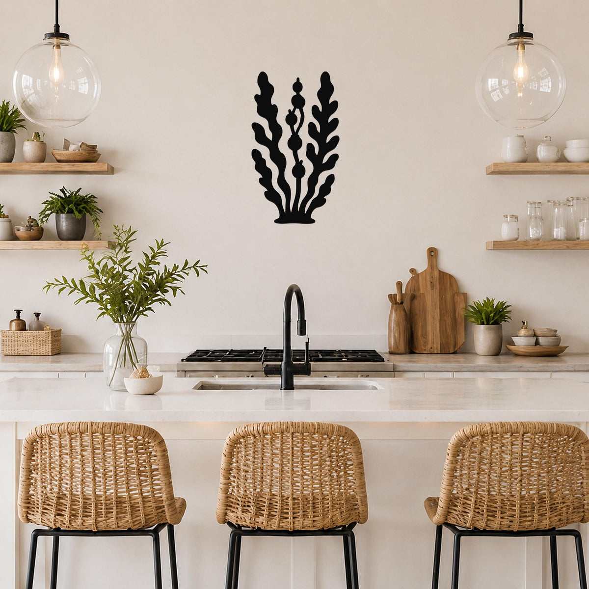 Black metal wall art in a kelp and seaweed silhouette with detailed frond cutouts, mounted on a kitchen wall above a counter.
