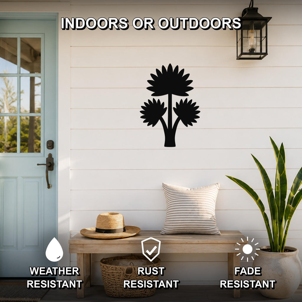 Black metal fan palm tree wall art with layered leaf cutouts, mounted on a white shiplap wall above a wooden bench on a porch.