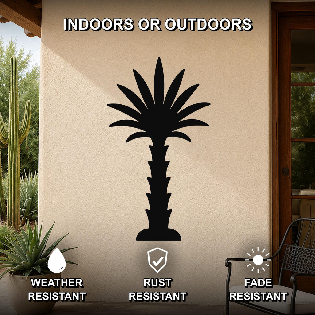 Black metal palm tree wall art silhouette mounted on an outdoor wall, weather resistant, rust resistant, and fade resistant, displayed on a patio with cacti and a chair nearby.