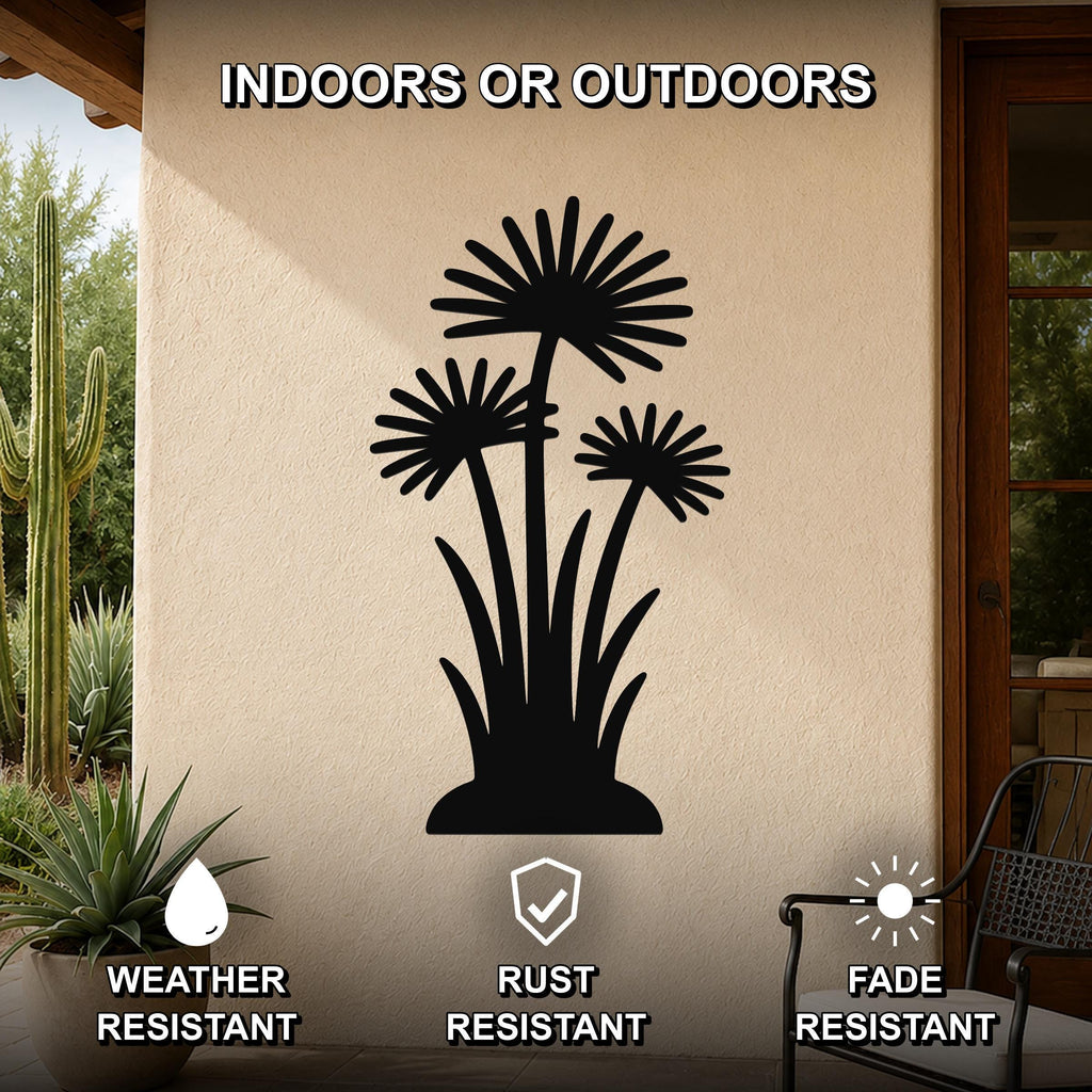 Black metal wall art featuring a silhouette of three wildflowers with long stems and spiky petals, mounted on an outdoor patio wall with cacti and plants visible nearby.