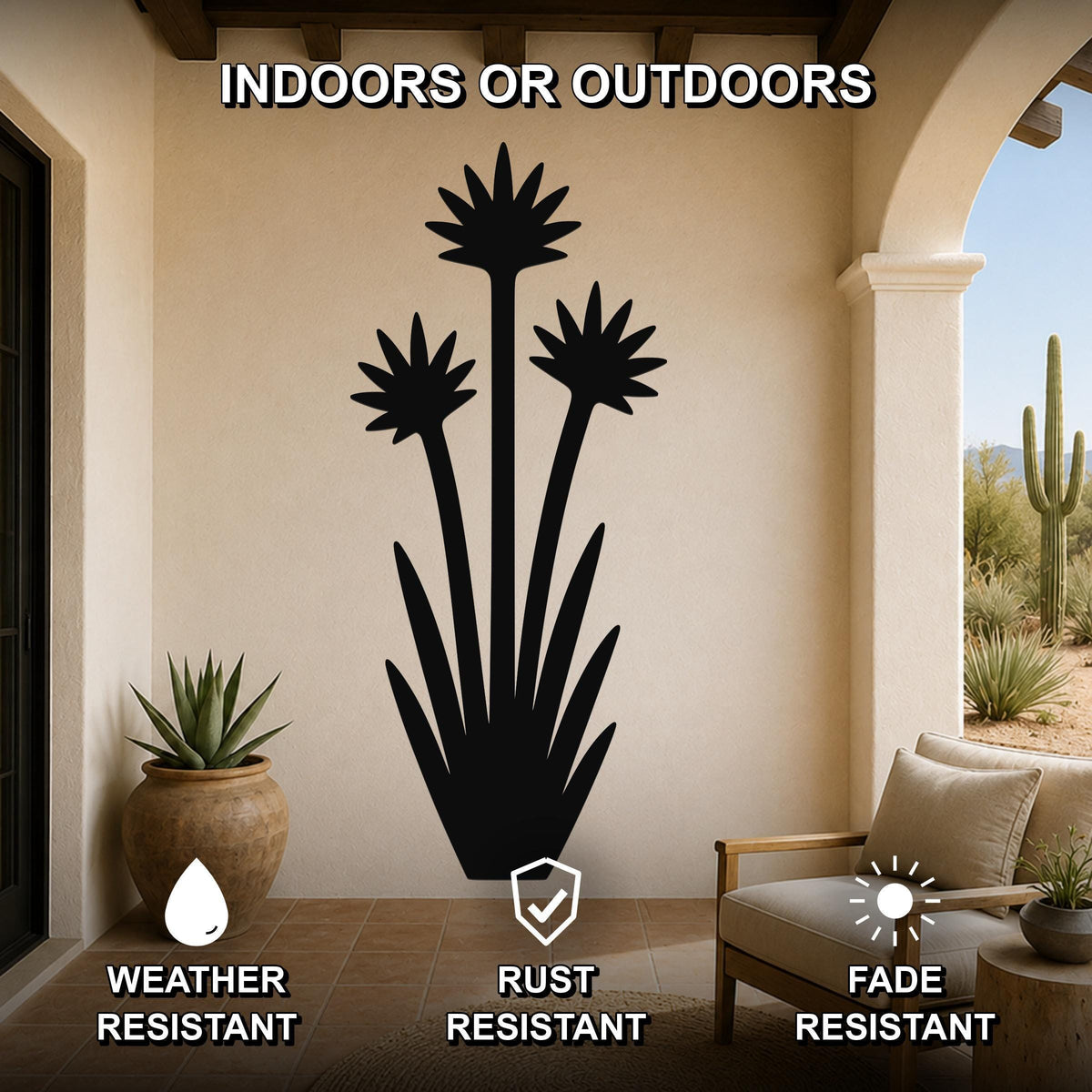 Black metal yucca wall art with three blooming flower cutouts and spiky leaves, mounted on a beige wall in a covered patio with outdoor furniture and potted plants.