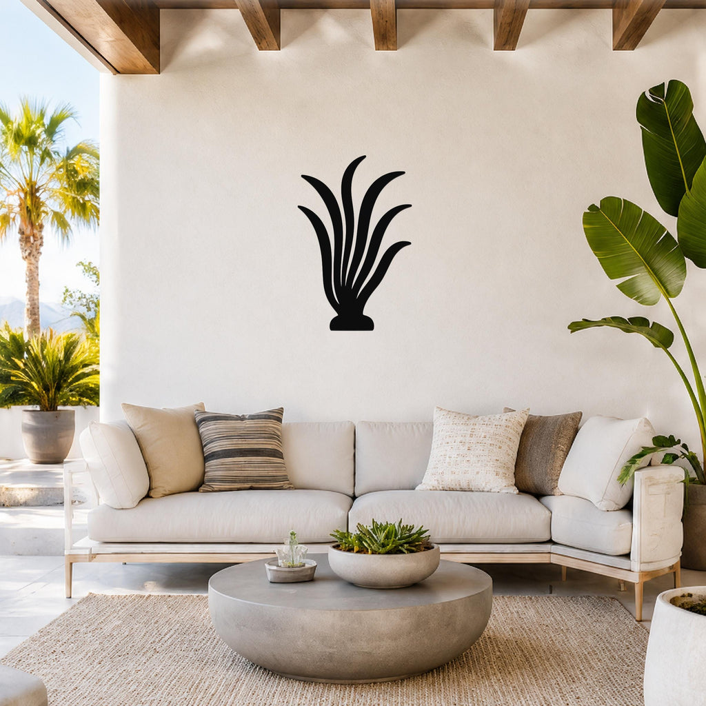Black metal kelp wall art silhouette mounted above a white sofa in a bright living room with wooden beams and potted plants.