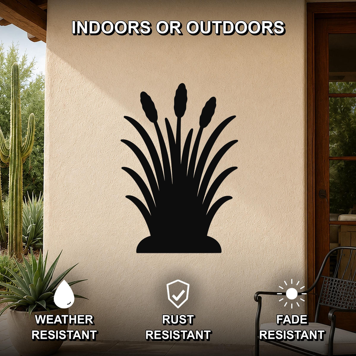 Black metal wall art silhouette of wild grass with tall seed heads, mounted on an outdoor patio wall beside a cactus and potted plant.