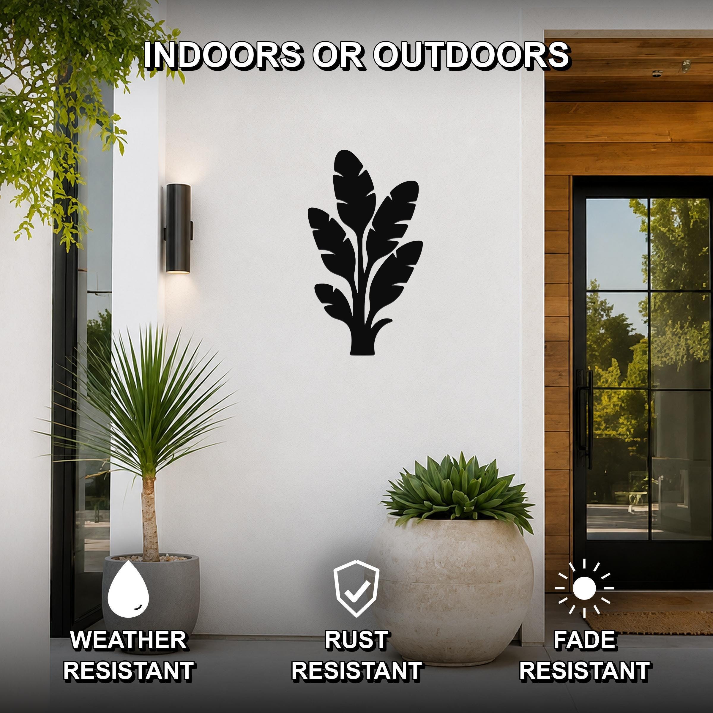 Black metal tropical leaves wall art silhouette mounted on a white outdoor wall beside a glass door and potted plants, weather, rust, and fade resistant.