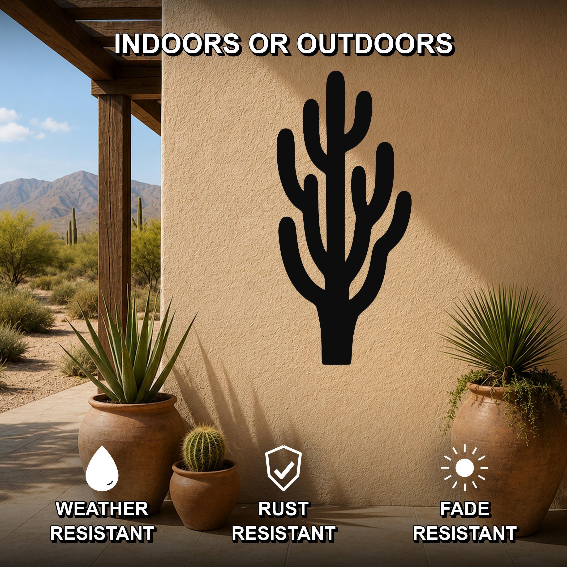 Black metal saguaro cactus wall art with branching cutouts, mounted on an outdoor patio wall above potted plants.