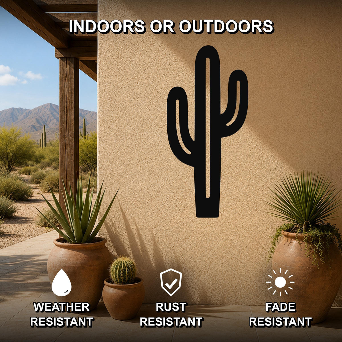 Black metal saguaro cactus wall art with cutout branches, mounted on a stucco outdoor wall above potted plants on a patio.
