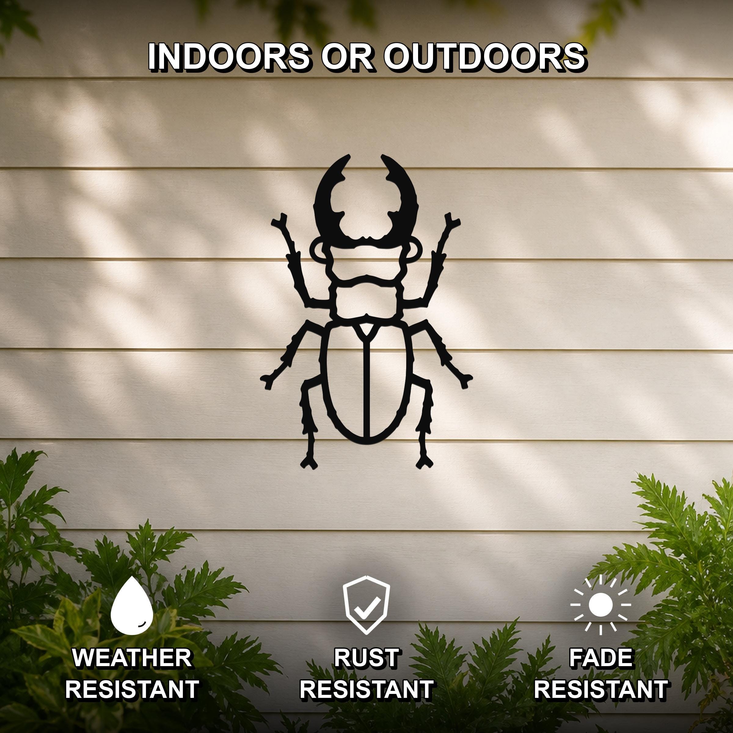 Black metal beetle wall art silhouette with detailed cutouts, mounted on a light-colored outdoor wall with greenery, weather, rust, and fade resistant.