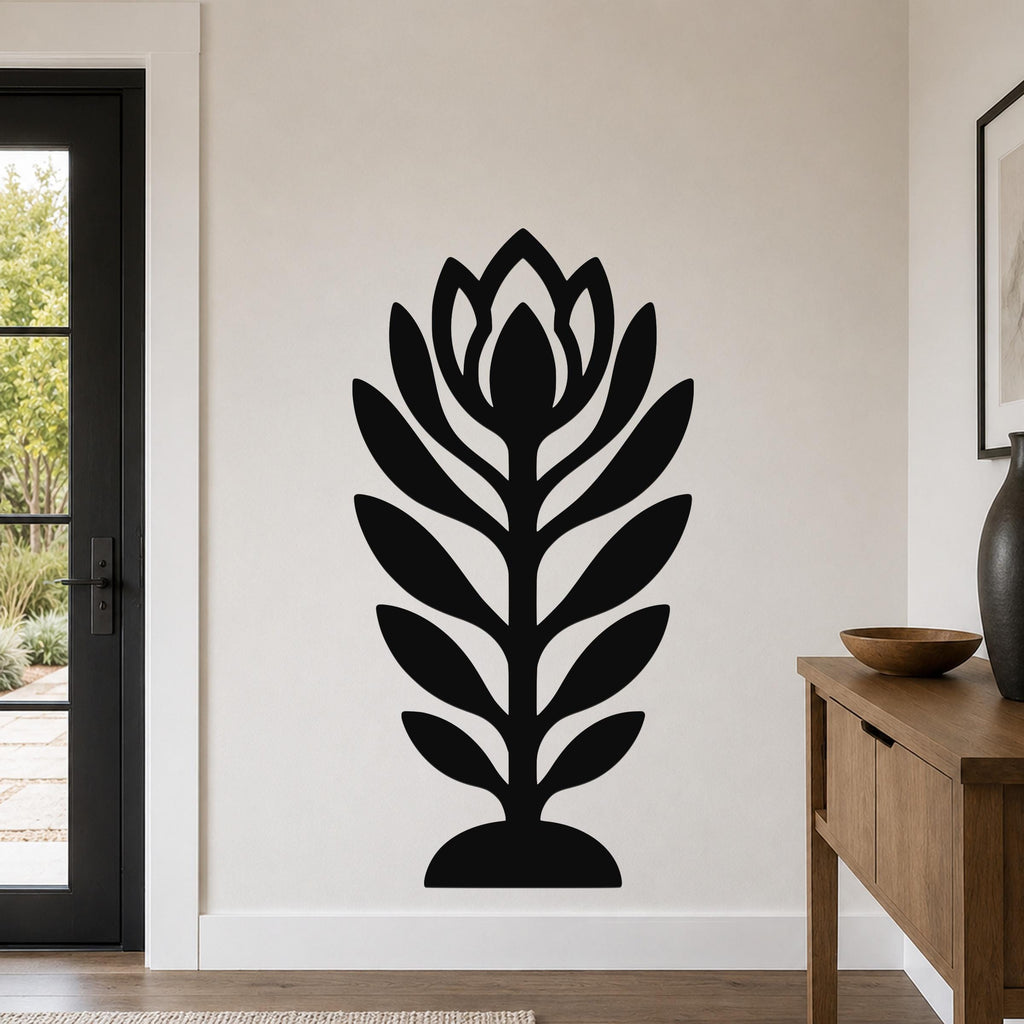 Black metal wall art in a stylized wildflower silhouette with layered petals and leaves, mounted on a living room wall above a wooden console table.
