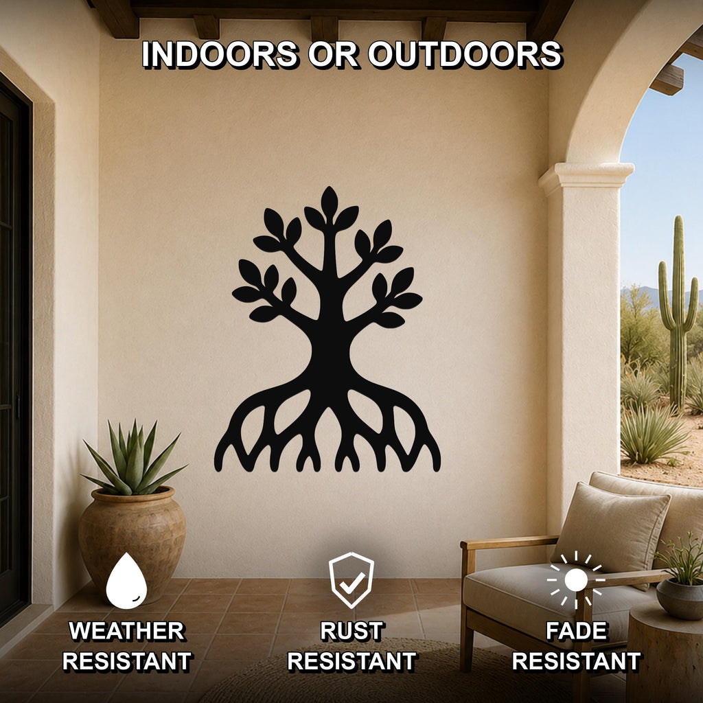 Black metal wall art in the shape of a tree with visible roots and leafy branches, mounted on an outdoor patio wall above a chair and potted plant.